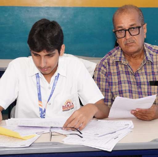 Senior student and guardian analysing answer scripts