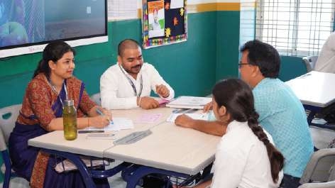 Teachers conducting one-on-one consultation with parent and student