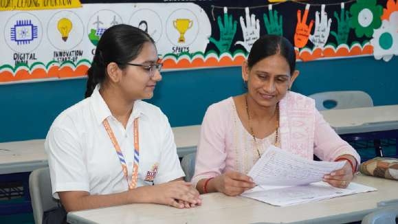 Girl student in spectacles and mother reviewing answer sheet