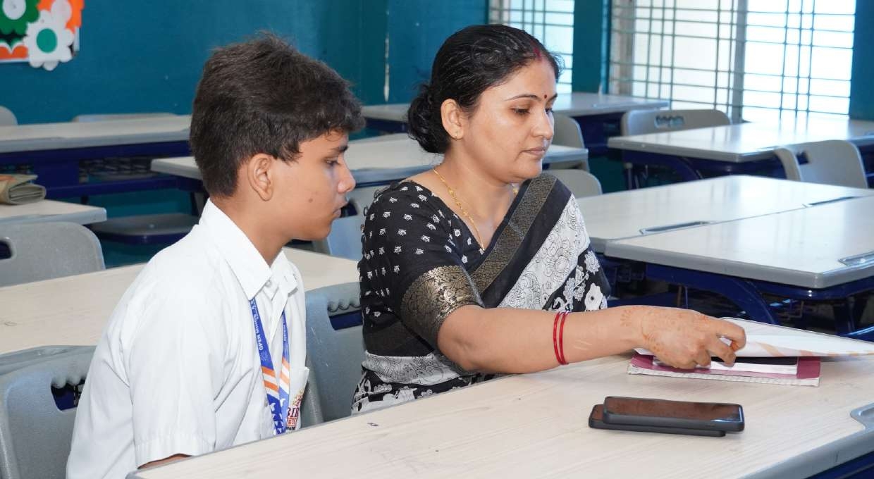 Student and mother examining evaluated subject notebooks