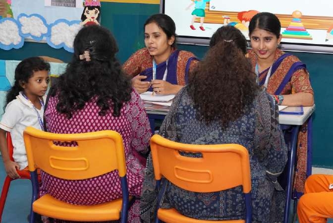 Primary educators consulting with mothers and young learners