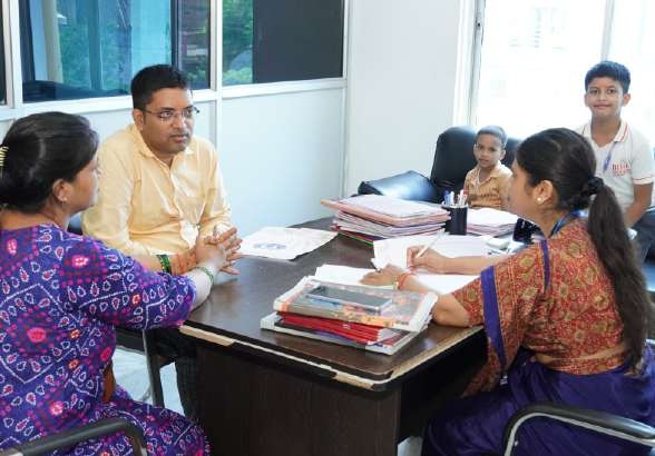 Parents consulting across desk in teacher's office