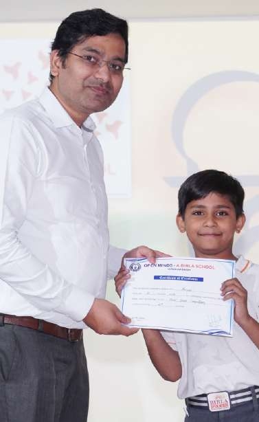 Principal presenting Certificate of Excellence to young student