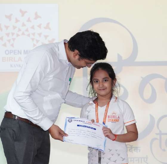 Principal presenting Certificate of Excellence to smiling young girl