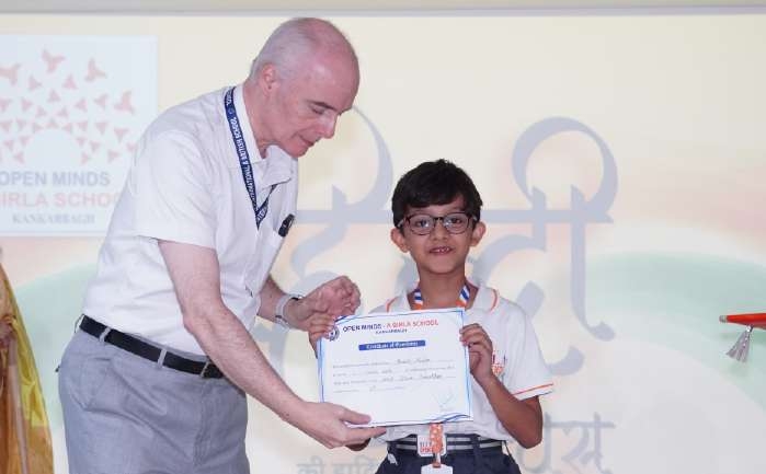 Guest presenting certificate to student with glasses
