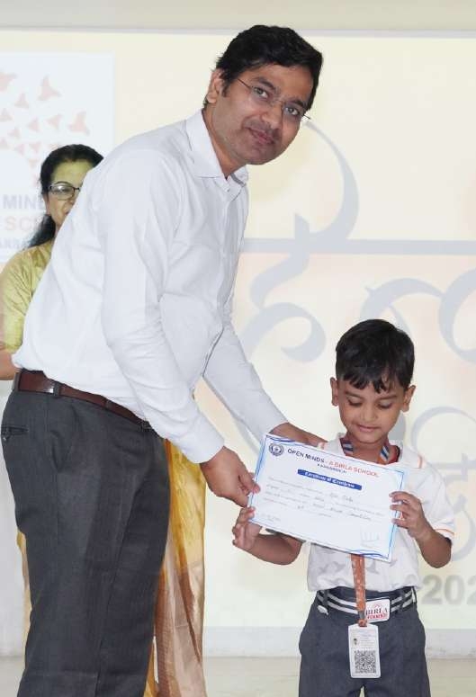 Principal presenting Certificate of Excellence to young boy