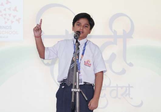 Student speaker in tie and badge speaking passionately with raised index finger