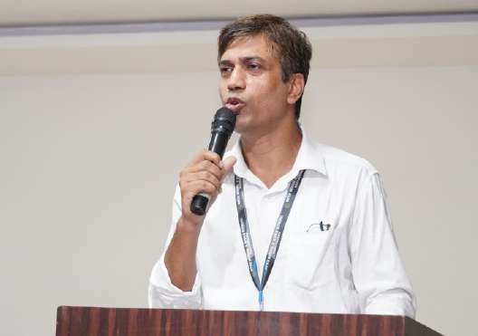 Teacher speaking with conviction into microphone at podium