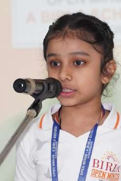 Young girl student reciting expressive poetry into microphone