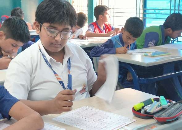 Student turning booklet page in examination hall